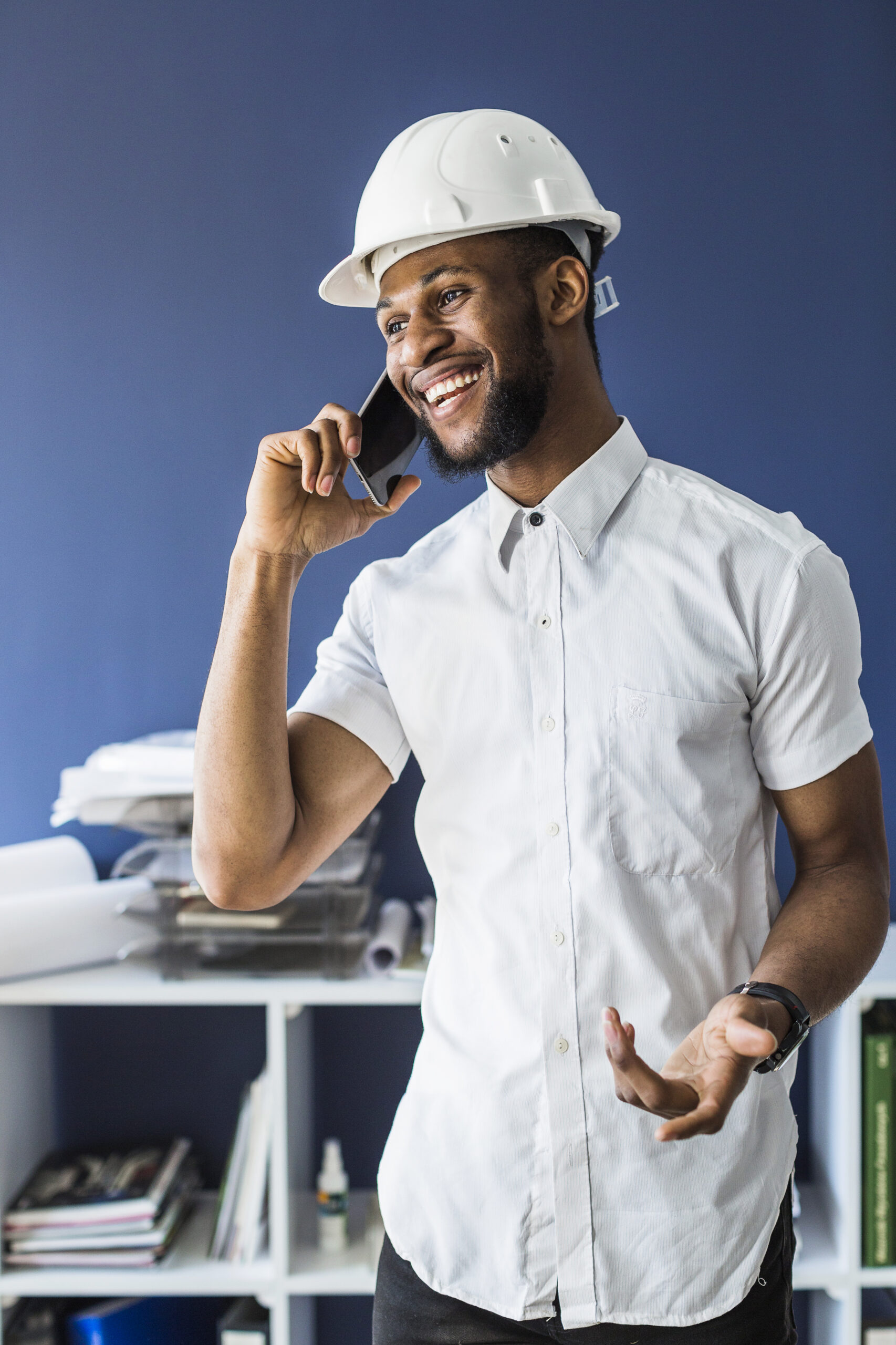 smiling-african-architect-talking-mobile-phone-office